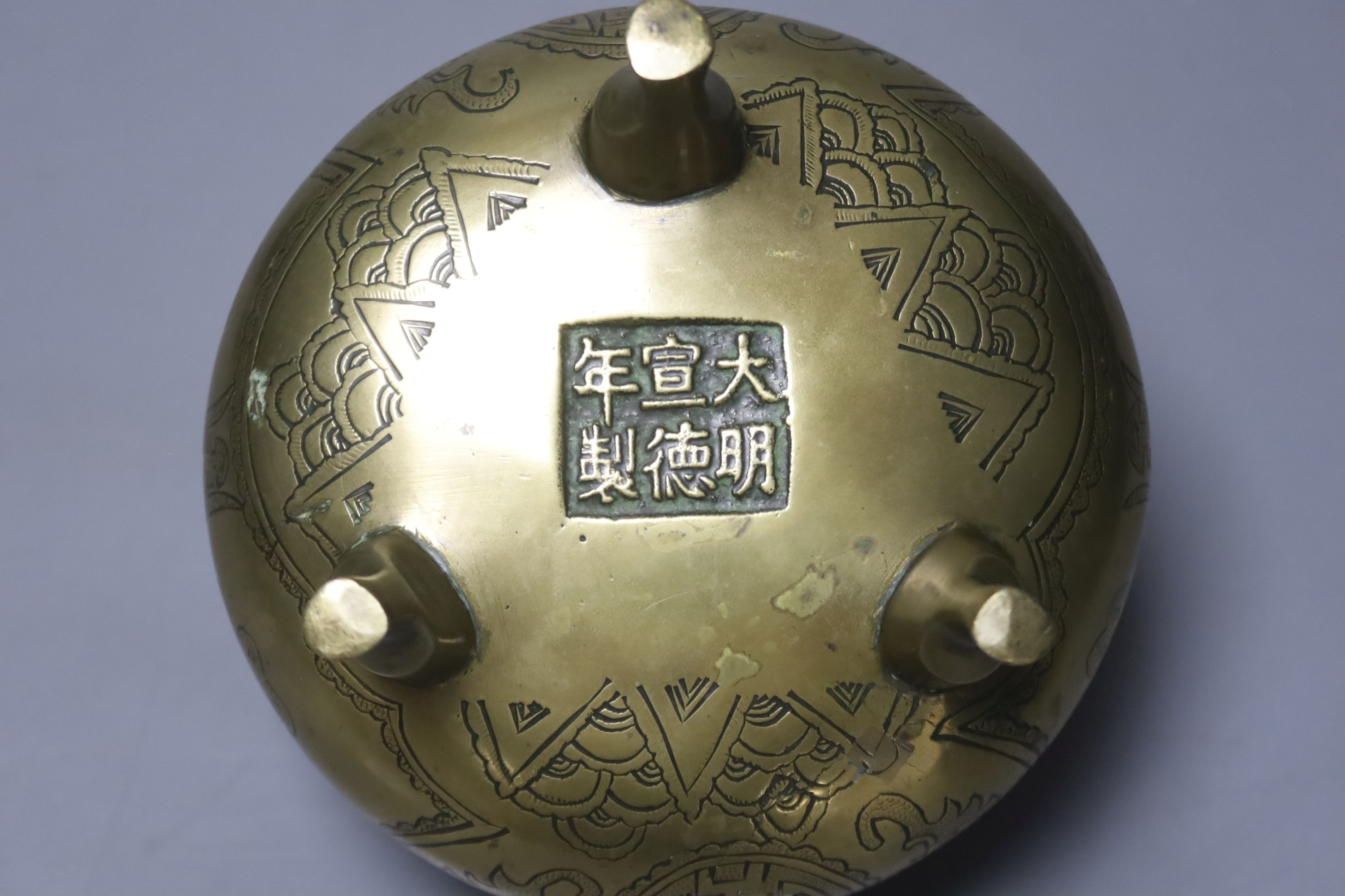 A 19th century Chinese engraved bronze tripod censer, Xuande mark to base, height 11cm